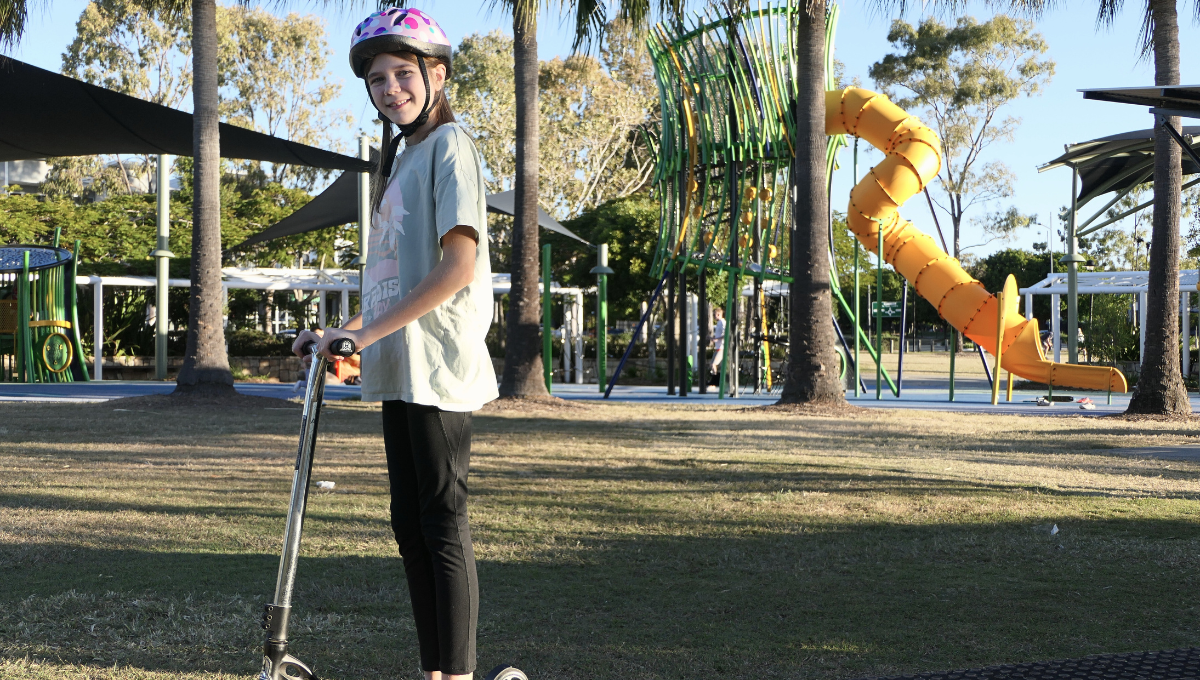 Girl on scooter at the playground