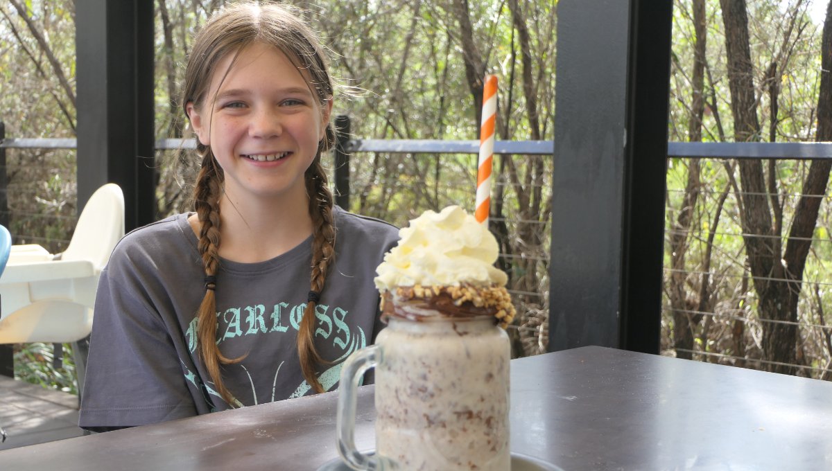 Girl enjoys a milkshake at Blue Infusion